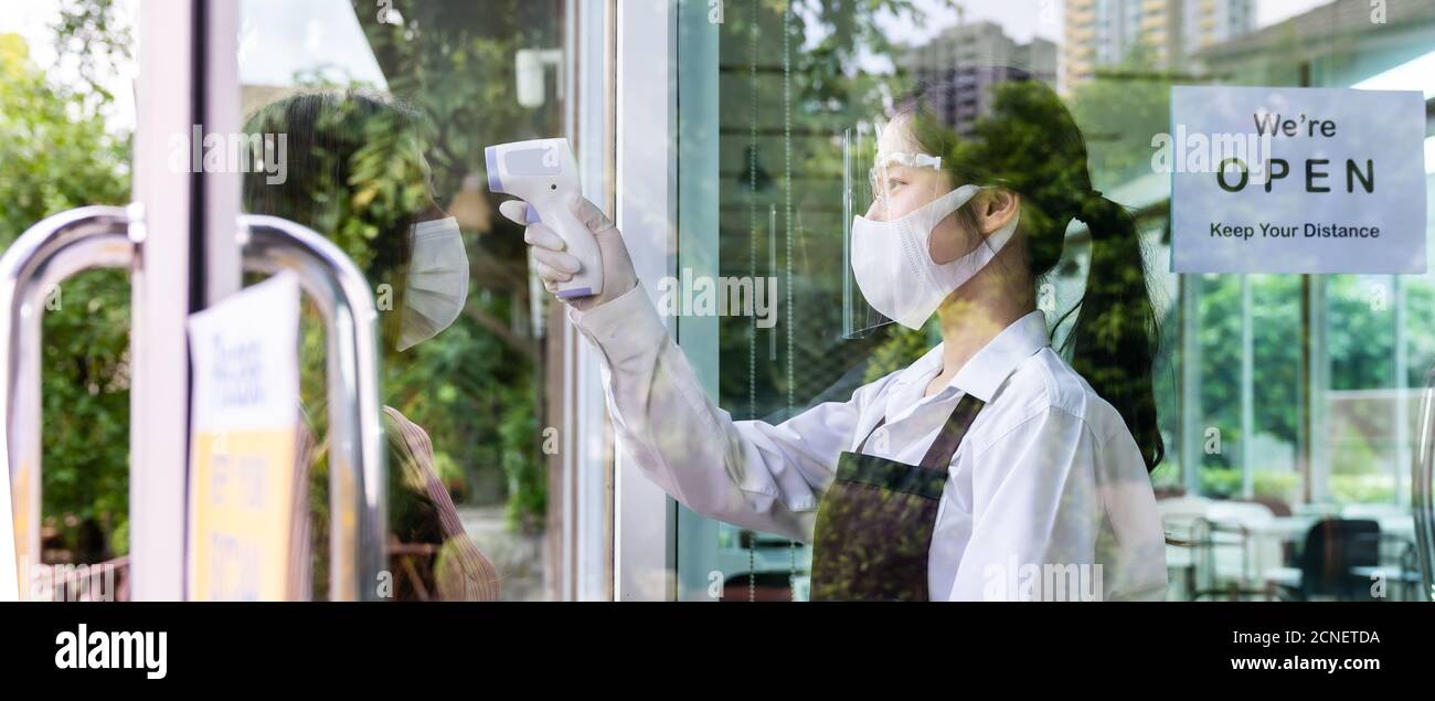 Panorama Waitress che porta la temperatura al cliente per il nuovo ristorante normale Foto Stock