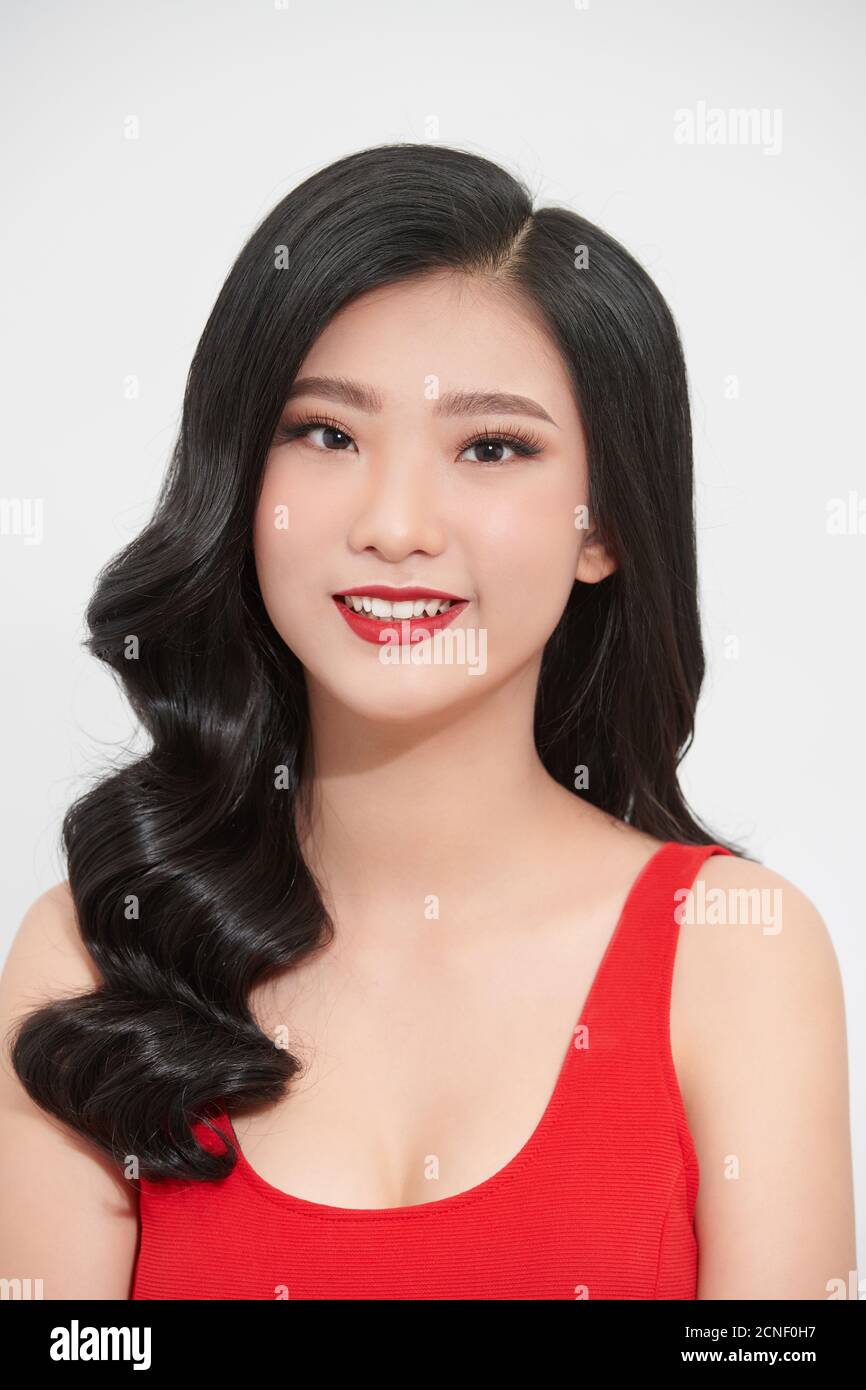 Ritratto di giovane bella ragazza asiatica sorridente guardando la macchina fotografica su sfondo bianco. Foto Stock