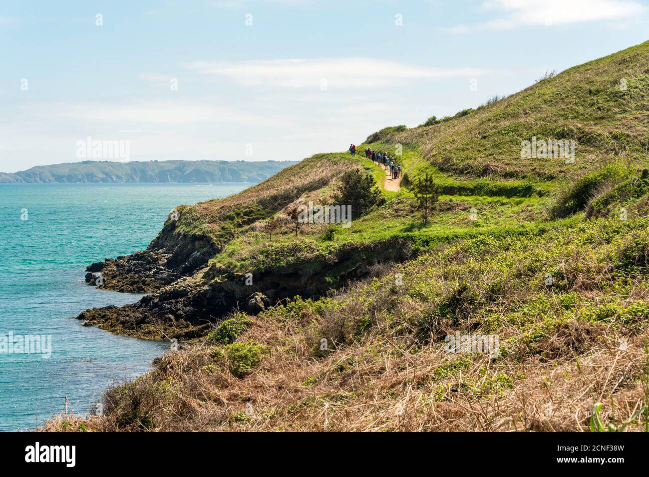 Un gruppo di escursionisti lascia Belvoir Bay, dirigendosi verso sud lungo il percorso costiero intorno a Herm Island, Guernsey, Isole del canale, Regno Unito. Foto Stock