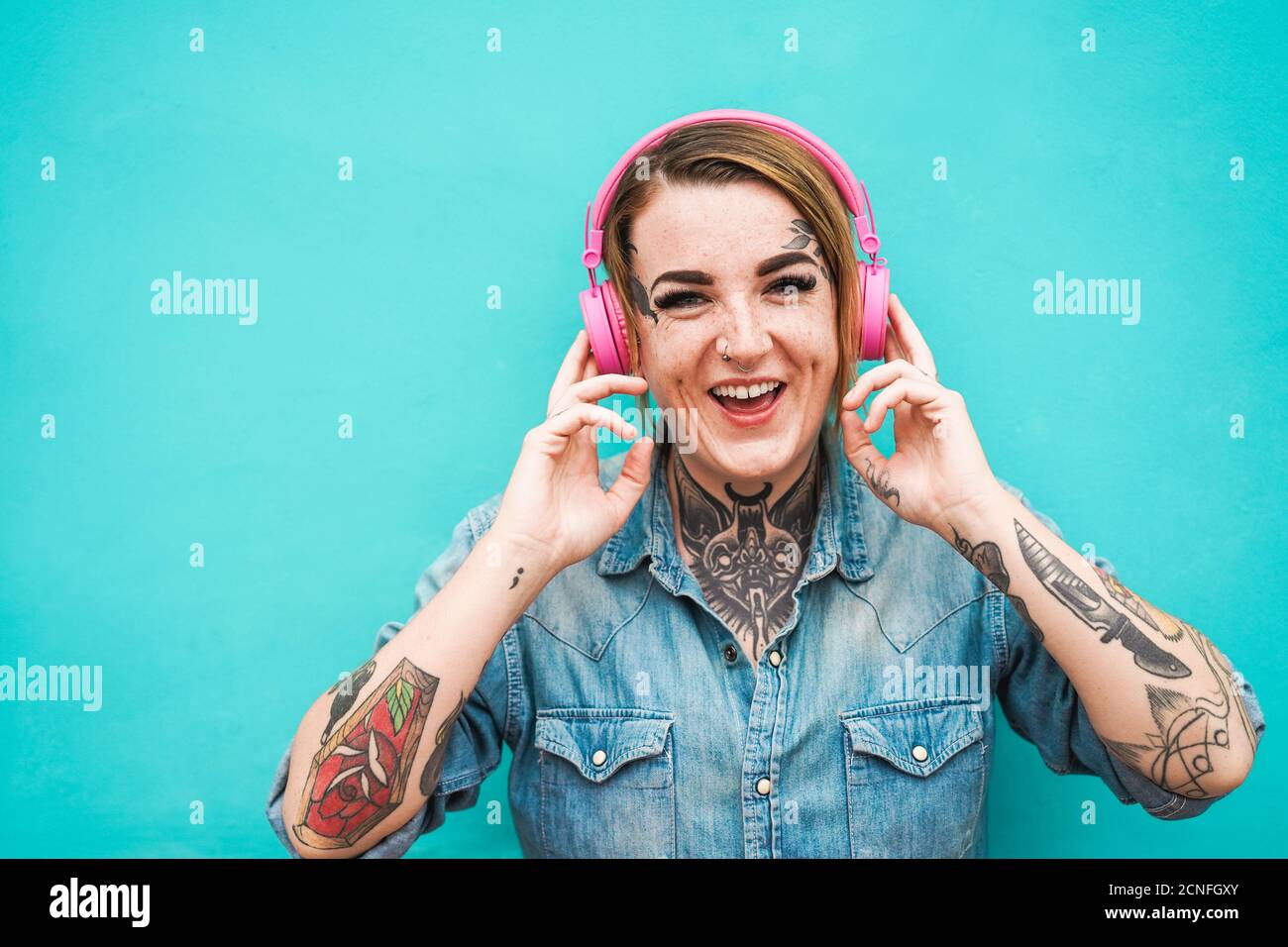 Tattoo girl che ascolta la musica con le cuffie Foto stock - Alamy
