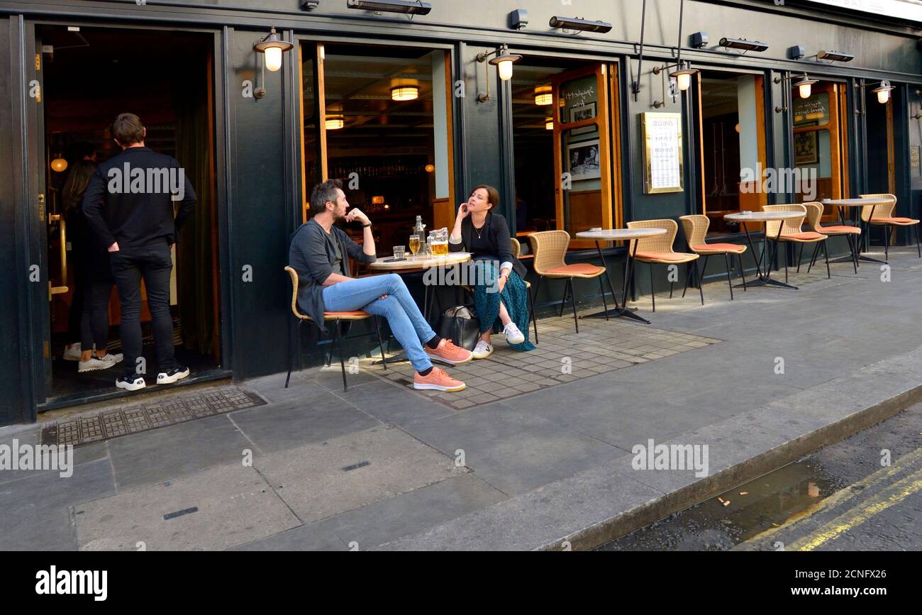 Londra, Inghilterra, Regno Unito. Persone sedute da sole fuori da un bar a Soho durante la pandemia di COVID, settembre 2020 Foto Stock