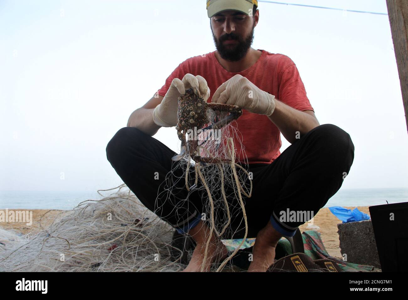 (200918) -- GAZA, 18 settembre 2020 (Xinhua) -- UN pescatore palestinese rimuove un granchio da una rete in un porto marittimo nella città di Gaza, il 18 settembre 2020. Secondo i rapporti, Israele ha esteso la zona di pesca al largo della costa della striscia di Gaza a 15 km (27.8 miglia nautiche) il 1 settembre. (Foto di Rizek Abdeljawad/Xinhua) Foto Stock