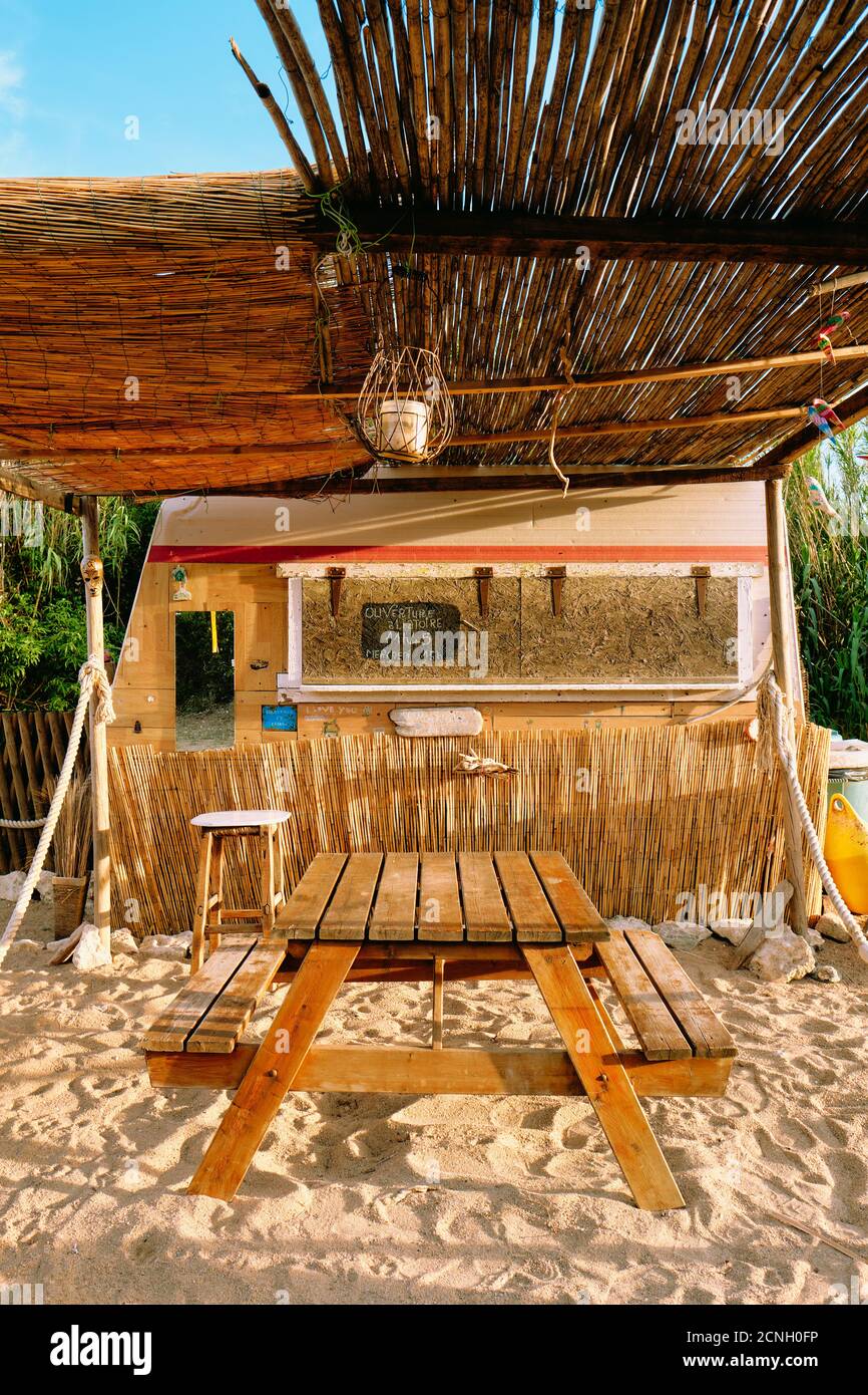 Un rustico summer beach bar cafe shack / cabana composto da materiali riciclati materiali rigenerati in Corsica Francia - Corsica Spiaggia cafe. Foto Stock