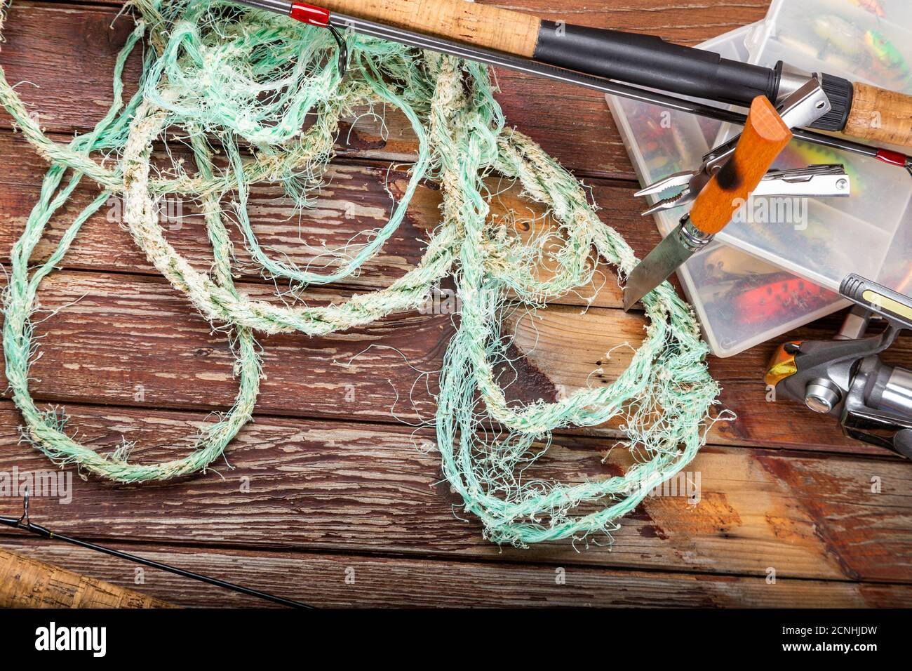 Diverse tegole da pesca con verga e bobine su sfondo marrone di legno. Mockap per la pubblicità e la pubblicazione. Foto Stock