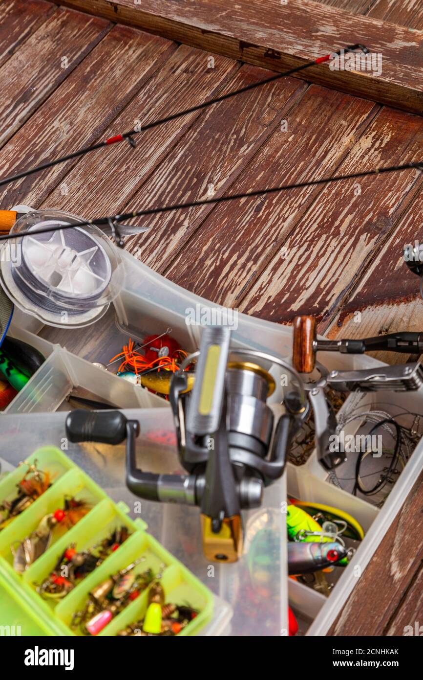 Diverse tegole da pesca con verga e bobine su sfondo marrone di legno. Mockap per la pubblicità e la pubblicazione. Foto Stock
