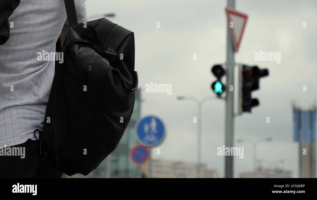 Giovane uomo che cammina su uno zaino verde e una borsa. Foto Stock
