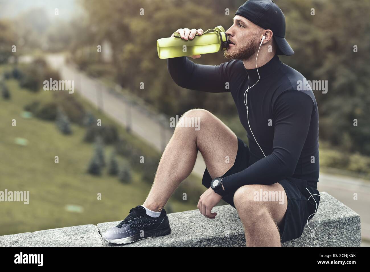 Close-up shot barbuto uomo sportivo prendere un periodo di riposo e di bere un acqua dopo la sessione di allenamento. Foto Stock