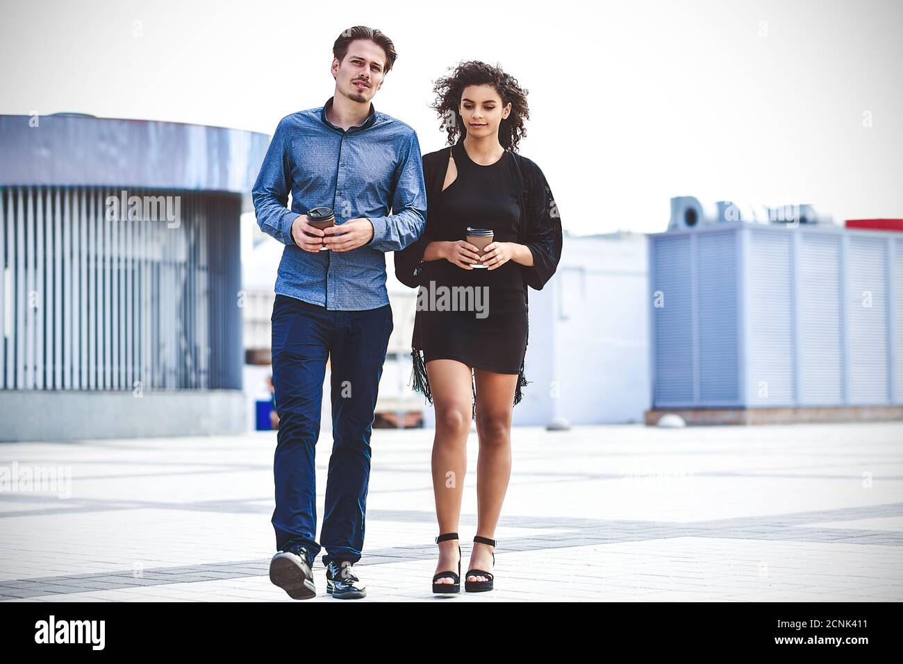 Incontro informale all'aperto in una giornata di sole. Coppia interracial a piedi in strada. Foto Stock