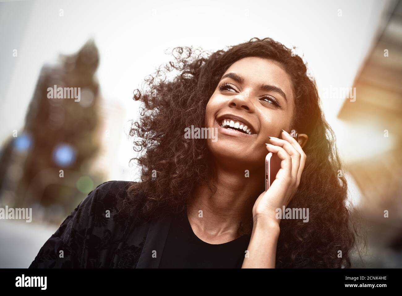 Emozioni positive. Concetto di stile di vita. Primo piano di una giovane donna di razza mista utilizzare un telefono. Foto Stock