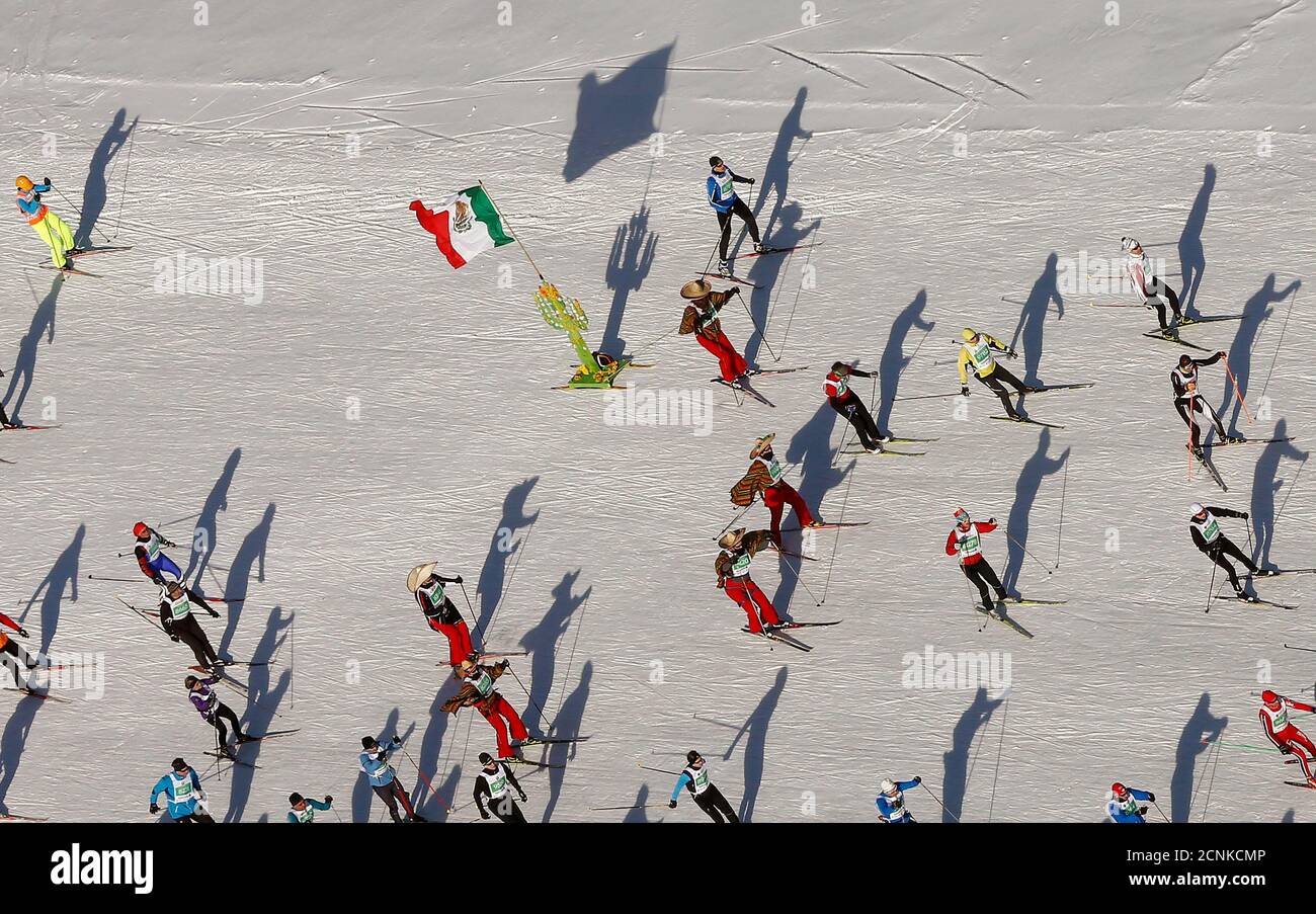 Una vista aerea mostra gli sciatori di fondo indossando sombreros e tirando una bandiera nazionale messicana mentre corrono durante la maratona sciistica di Engadin nel villaggio di Maloja 8 marzo 2015. Secondo gli organizzatori, più di 13,000 sciatori hanno partecipato alla gara di 42 km (26 miglia) tra Maloja e S-chanf vicino alla stazione sciistica svizzera di St. Moritz. REUTERS/Arnd Wiegmann (SVIZZERA - Tags: SOCIETÀ DELLO SCI SPORTIVO) Foto Stock