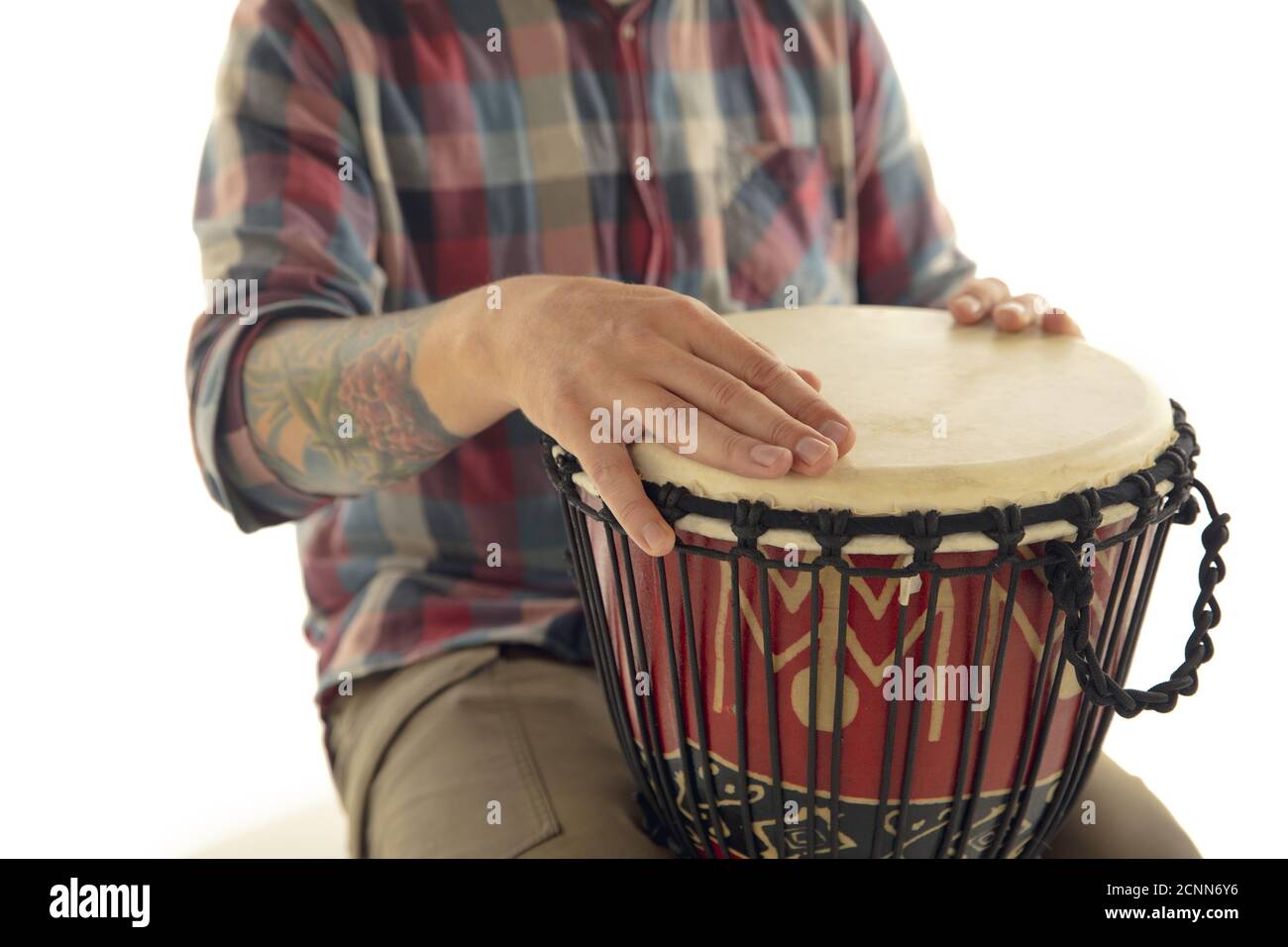 L'uomo suona percussioni etniche drum darbuka, primo piano musicista  isolato su sfondo bianco studio. Mani maschili che toccano djembe, bongo a  ritmo. Strumenti musicali fatti a mano, suono della cultura mondiale Foto