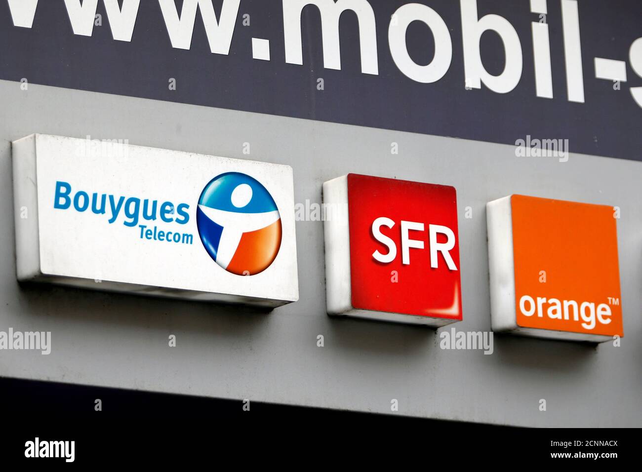 Gli operatori francesi di telecomunicazioni Bouygues Telecom, SFR, e Orange  loghi sono visti su un negozio di telefonia mobile a Parigi, Francia, 15  dicembre 2015. Lunedì il ministro dell'Economia francese ha dichiarato