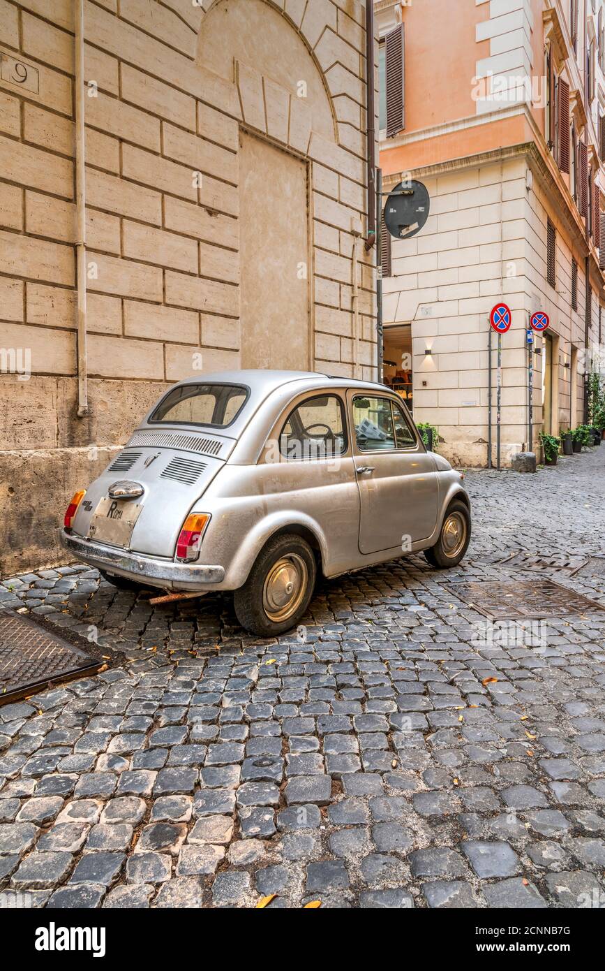 Vecchia classica Fiat 500 parcheggiata in una strada acciottolata di Roma, Lazio, Italia Foto Stock