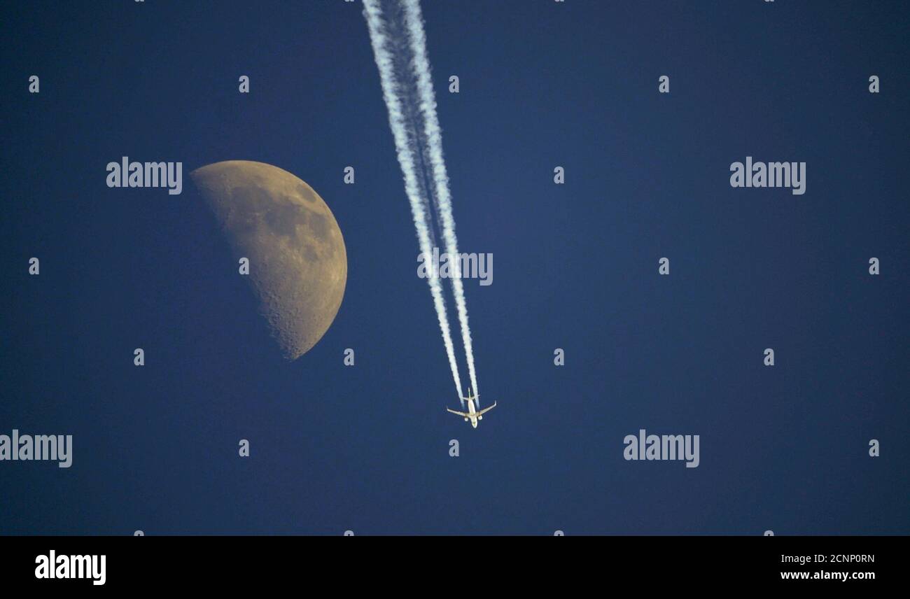 An aircraft flies past the moon over Anterselva, northwest Italy, January 23, 2010. REUTERS/Alessandro Bianchi (ITALY - Tags: TRANSPORT ENVIRONMENT IMAGES OF THE DAY) Foto Stock