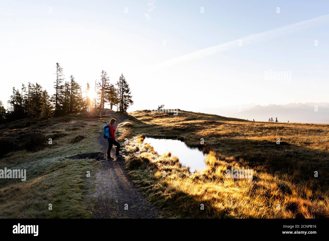 Donna in piedi al buco d'acqua sulla cima Rossbrand al mattino, in Austria Foto Stock