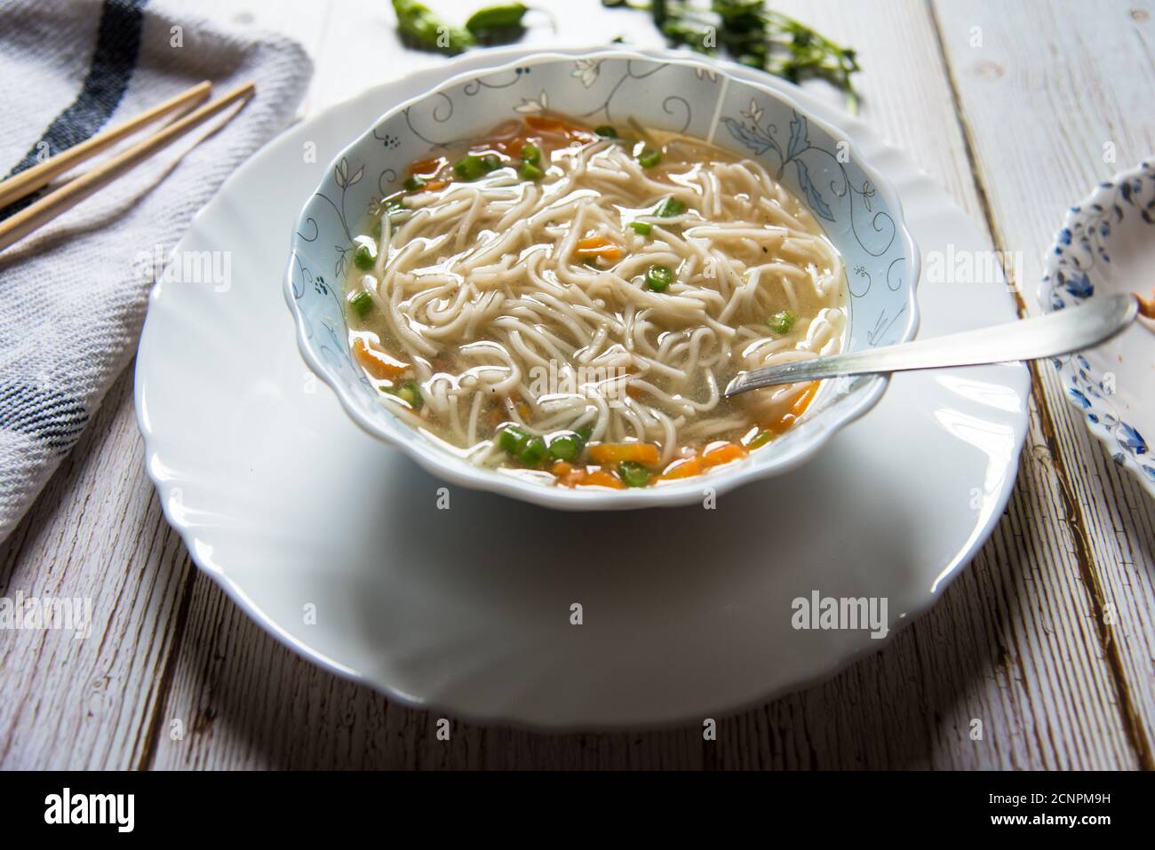 Thukpa, una delicatezza tibetana in una ciotola su un piatto bianco su uno sfondo. Foto Stock