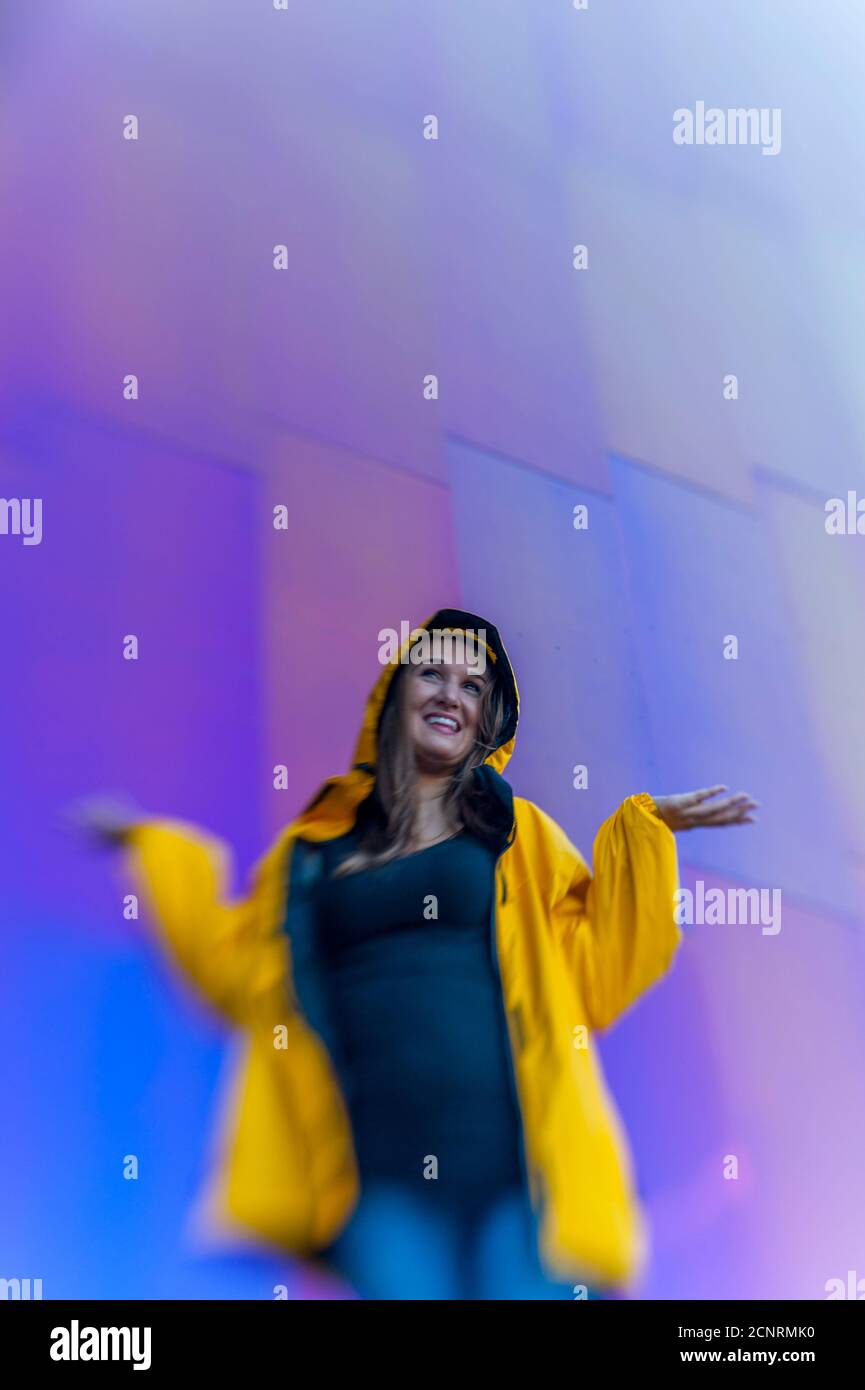 Dettaglio dell'architettura metallica del Museo della Pop Culture (progettato da Frank O. Gehry) con una donna (modello rilasciato) che controlla la pioggia al sedile Foto Stock