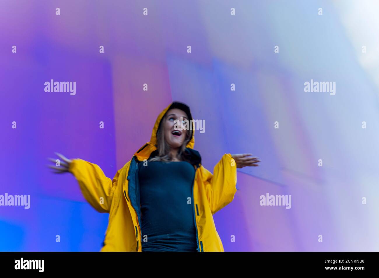 Dettaglio dell'architettura metallica del Museo della Pop Culture (progettato da Frank O. Gehry) con una donna (modello rilasciato) che controlla la pioggia al sedile Foto Stock