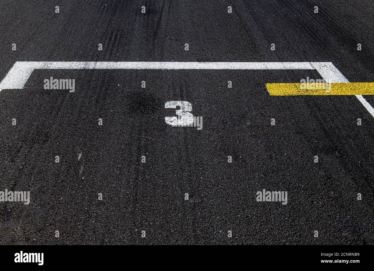 Posizione della vista ad angolo alto primo piano numero tre in posizione di attivazione pista asfalto da corsa motorsport Foto Stock