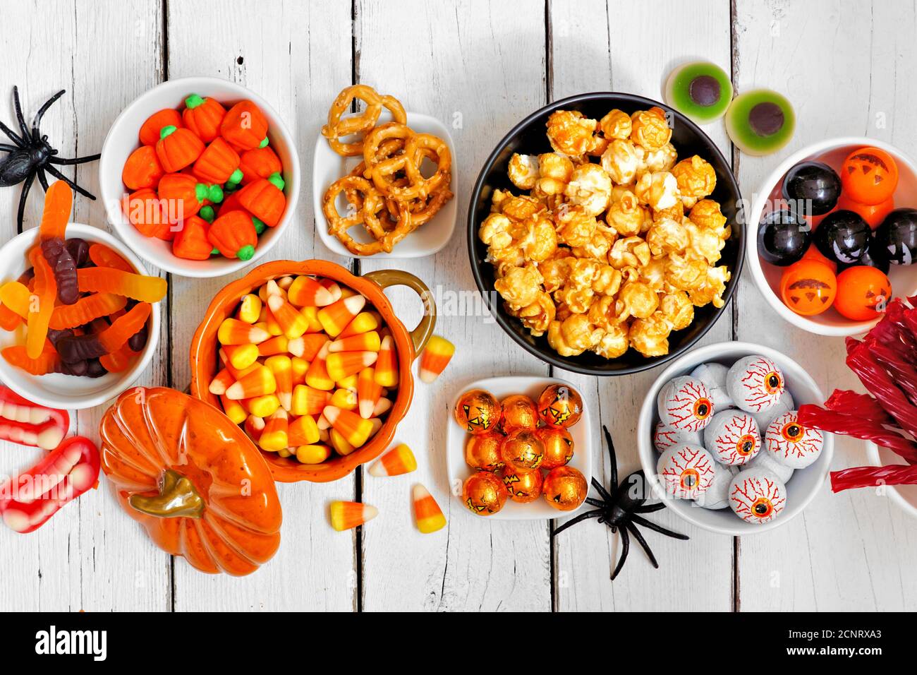 Halloween caramella scena del tavolo a buffet su uno sfondo di legno bianco. Assortimento di divertimento e di sorprese. Vista dall'alto. Foto Stock