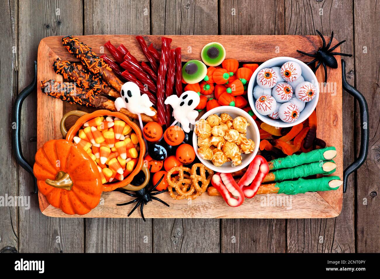 Vassoio caramelle Halloween su uno sfondo rustico di legno. Assortimento di dolci prelibatezze speziate. Vista dall'alto. Concetto di buffet per feste. Foto Stock