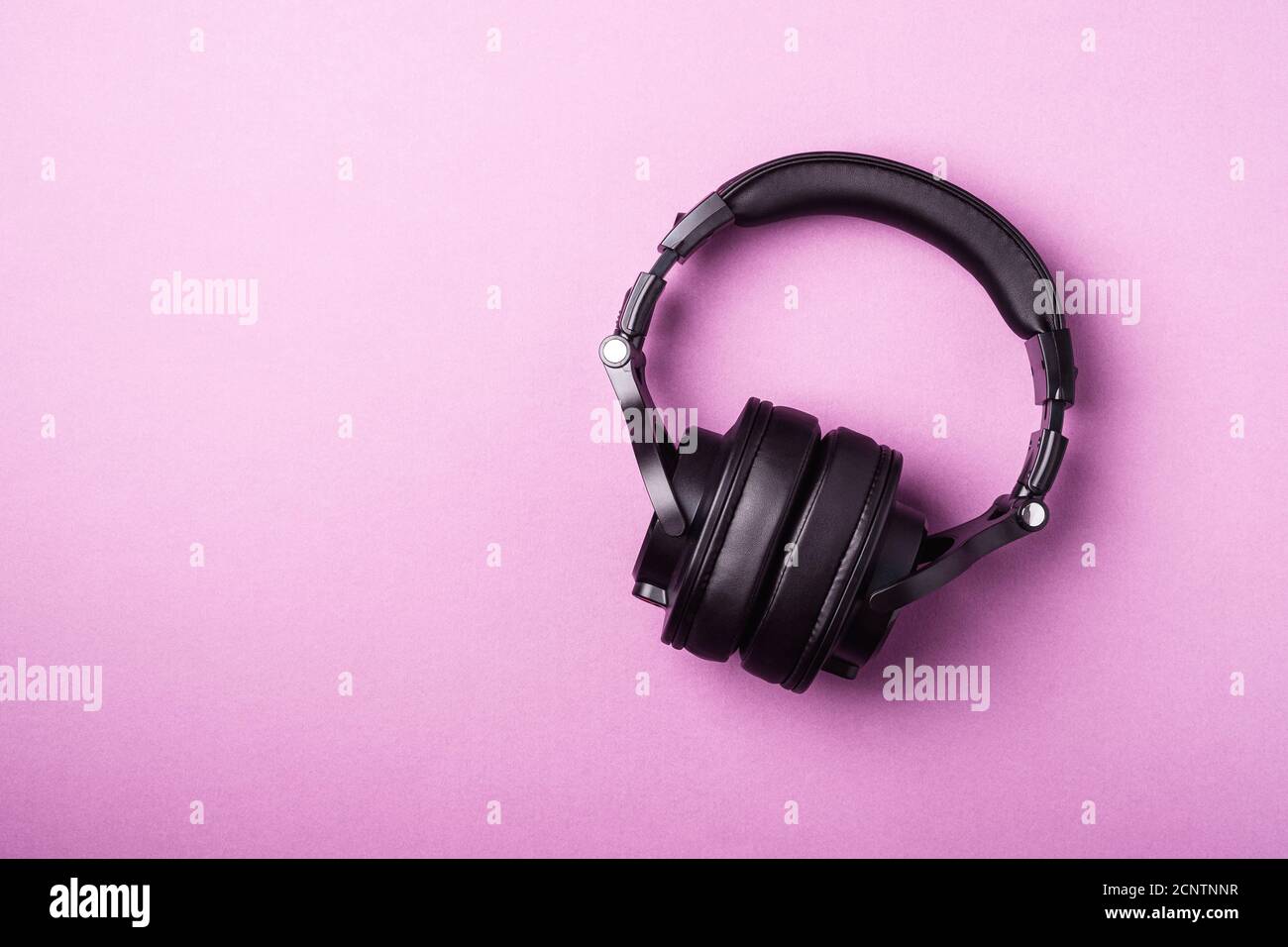 Cuffie wireless nere classiche su sfondo rosa Foto Stock
