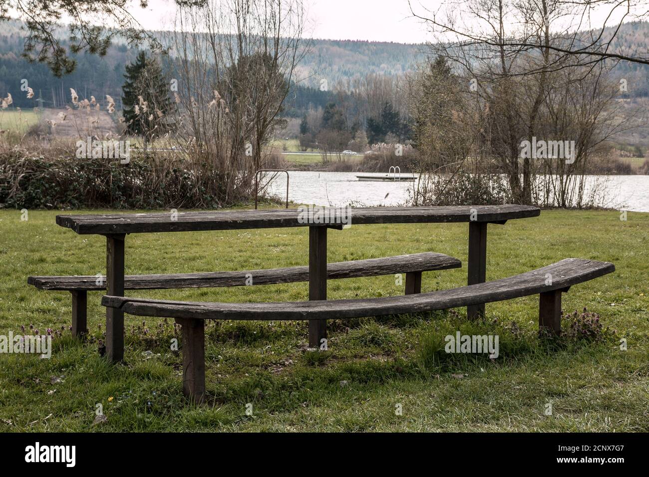 Parcheggiare panca e tavolo sull'erba verde vicino il lago Foto Stock
