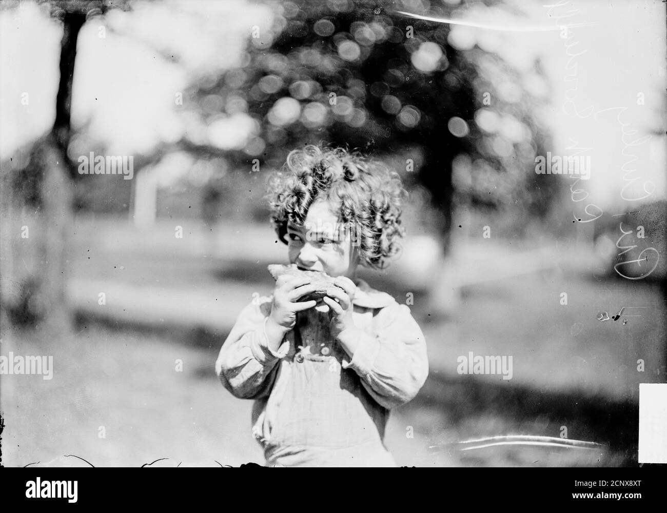 Ritratto informale di mezza lunghezza di una ragazza che mangia un panino. L'immagine è stata presa al Camp Goodwill a Evanston, Illinois, 1905. Foto Stock