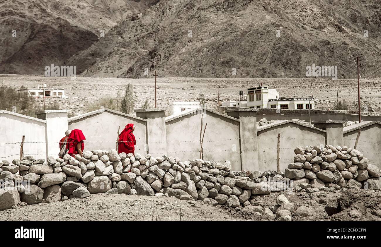 Monastero di Thiksay nel villaggio di Thiksey, India – 20 agosto 2016: Il gruppo di monaci tibetani in tombi rossi passa dal paesaggio incolore nel villaggio di Thiksey Foto Stock