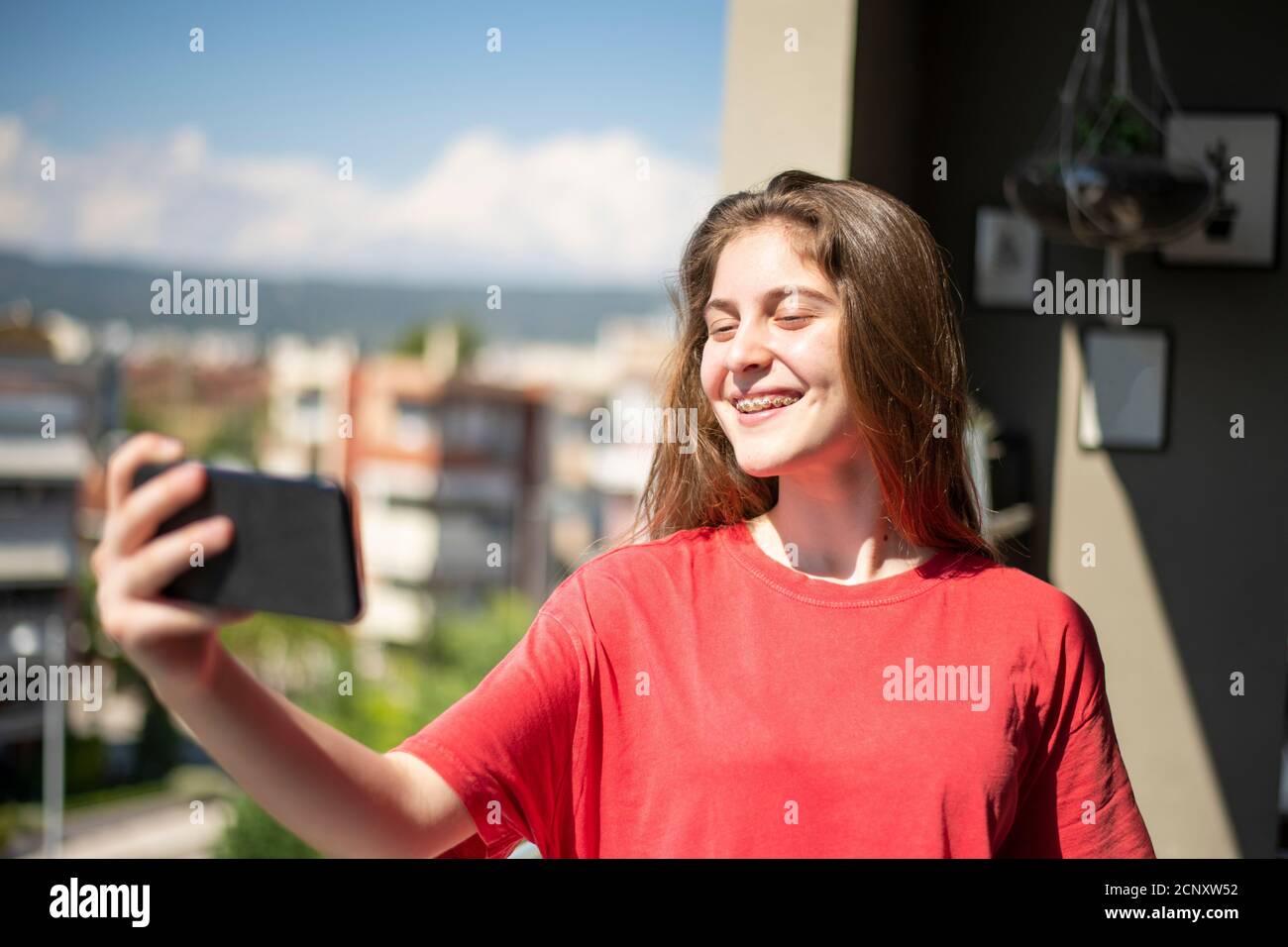 Bella giovane ragazza che prende Selfie con il suo cellulare. Concetto domestico Foto Stock