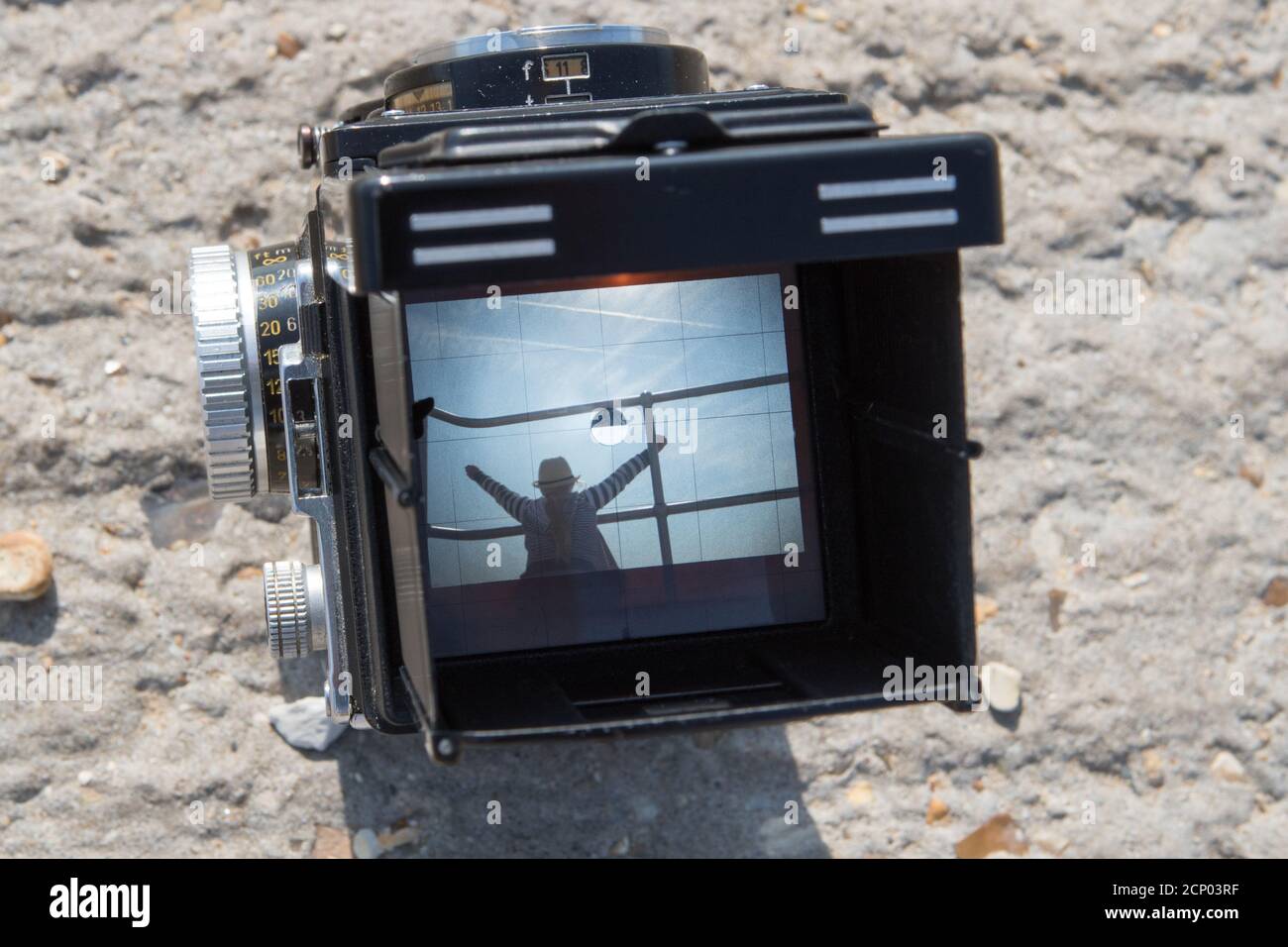Una fotocamera reflex doppia Rolleiflex vintage che incornicia un soggetto una scena da spiaggia nel mirino Foto Stock