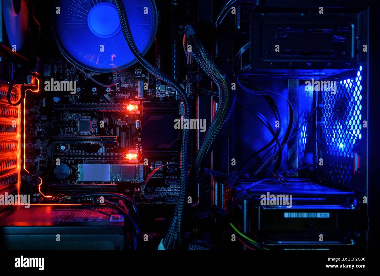 Computer con luci LED RGB interne e ventole di raffreddamento CPU, hardware all'interno di un PC desktop aperto ad alte prestazioni. Il computer di gioco aperto per lo sfondo. Foto Stock