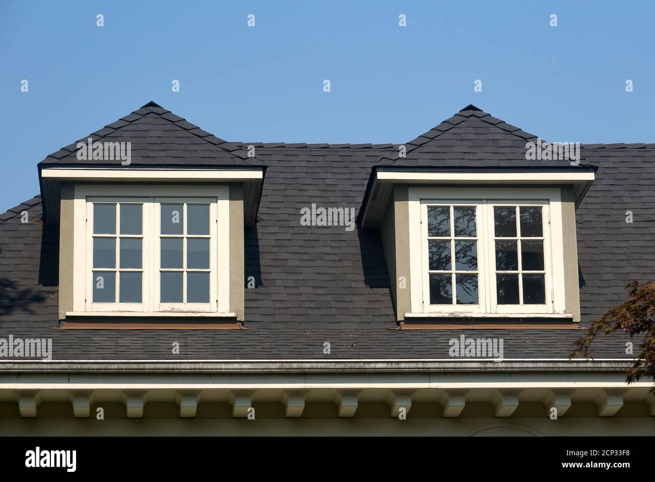 Finestre in legno con tetto in legno a tegole in tetto a falde di una casa Foto Stock