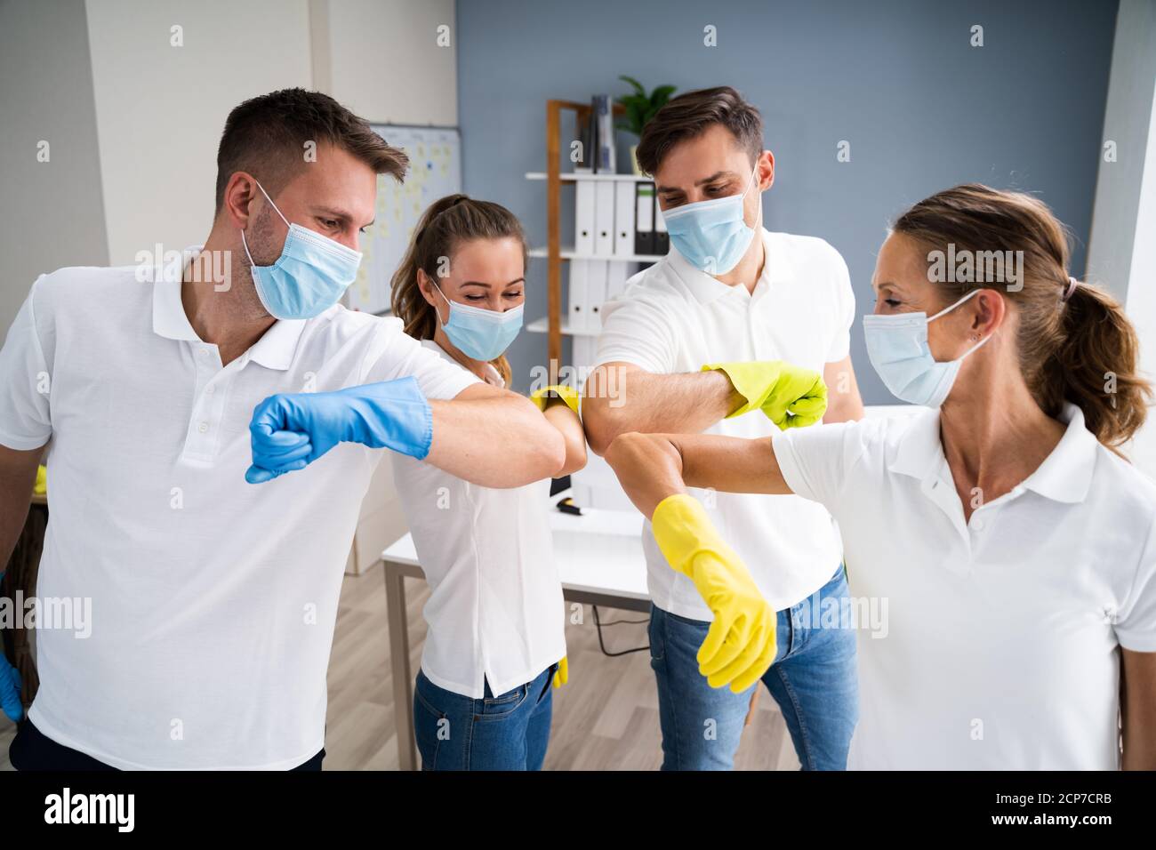 Ufficio professionale pulizia Janitor Team Spirit e Huddle con viso Maschere Foto Stock