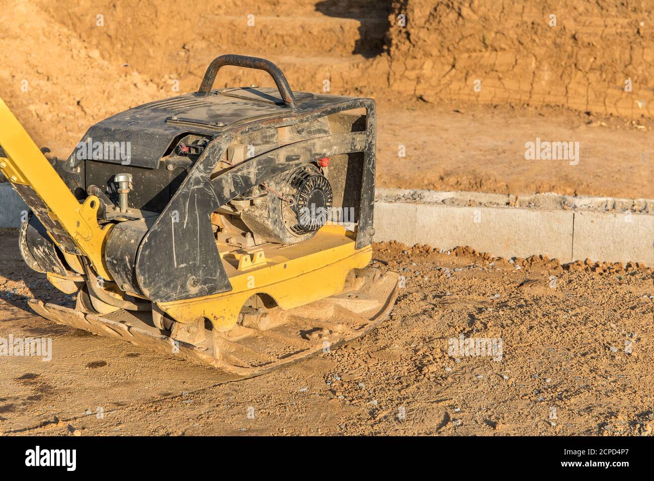 Compattatore a piastra vibrante in costruzione. Compattatore a piastra vibrante in cantiere. Attrezzature da costruzione. Utensile di compattazione liscio Foto Stock