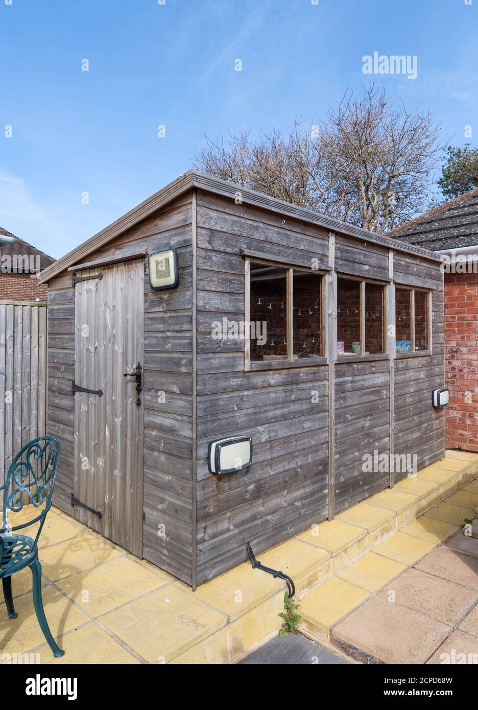 Capannone privato in legno con finestre in un giardino posteriore nel Regno Unito. Foto Stock