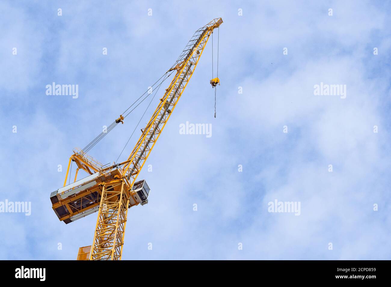 Cantiere con gru sullo sfondo del cielo. Grande macchina gialla costruzione gru utensile di edilizia per il sollevamento pesante su sfondo blu cielo Foto Stock