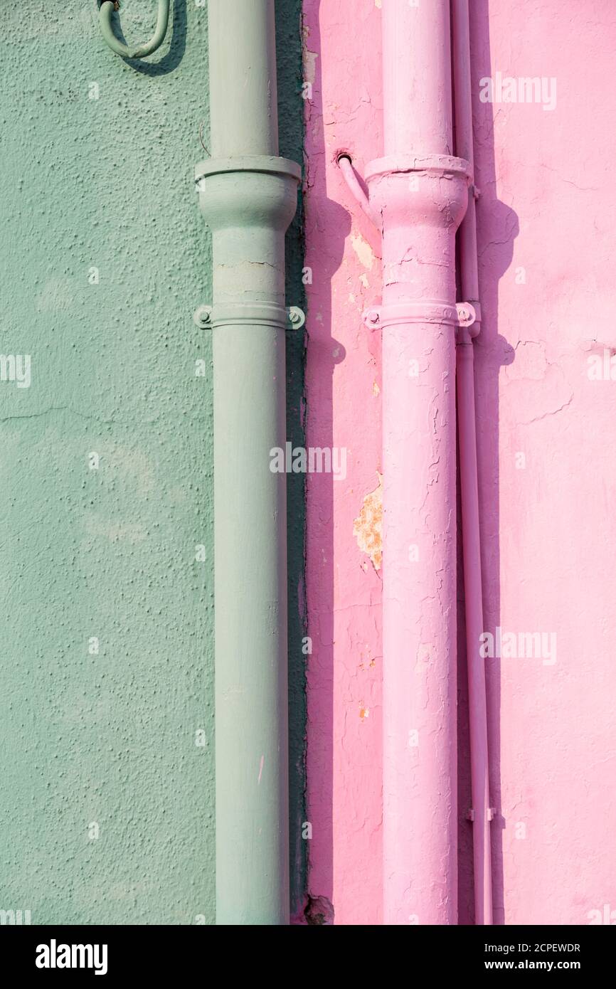 Primo piano di una linea di tubi colorata sulla parete esterna di una casa a Burano, Venezia, Veneto, Italia Foto Stock