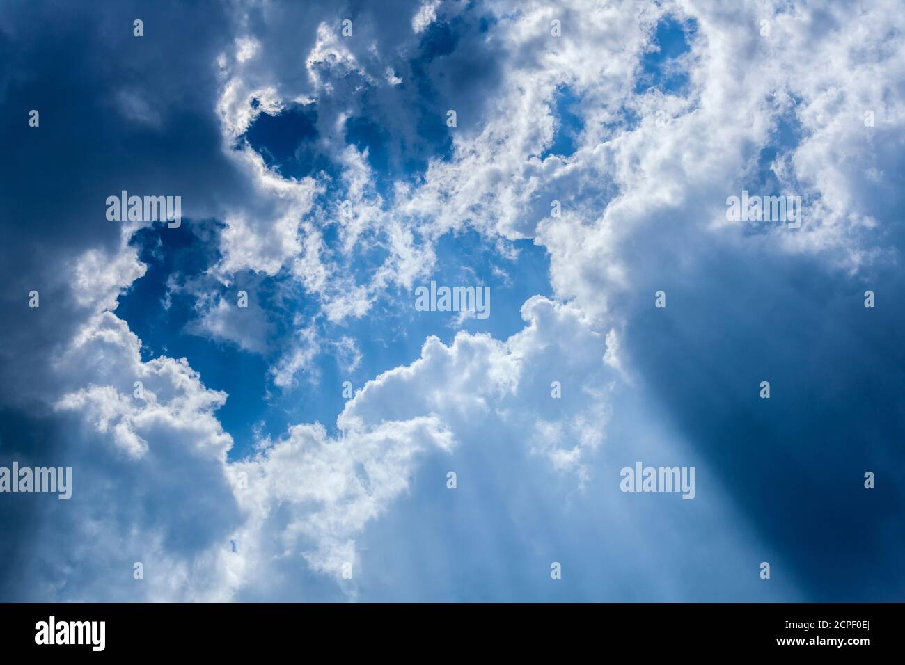 Il cielo blu con nuvole e raggi solari Foto Stock