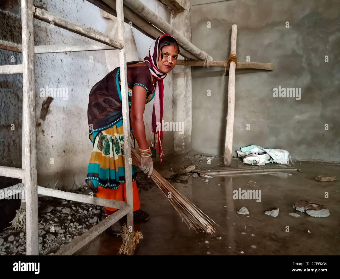 DISTRETTO KATNI, INDIA - 18 GENNAIO 2020: Una donna indiana che pulisce il pavimento dell'acqua sul luogo costruito interno dell'edificio. Foto Stock