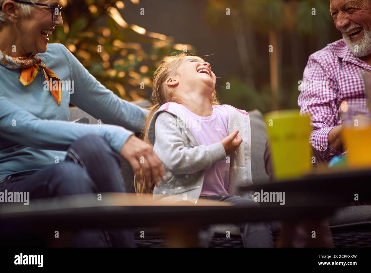 nipote caucasica ridendo forte con i suoi nonni, avendo tempo meraviglioso Foto Stock