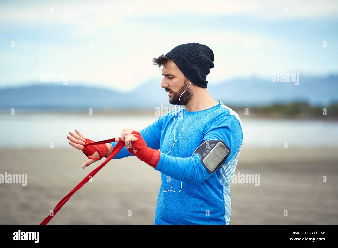 Ragazzo giovane che si prepara per un addestramento di boxe su una spiaggia con un bel tempo Foto Stock