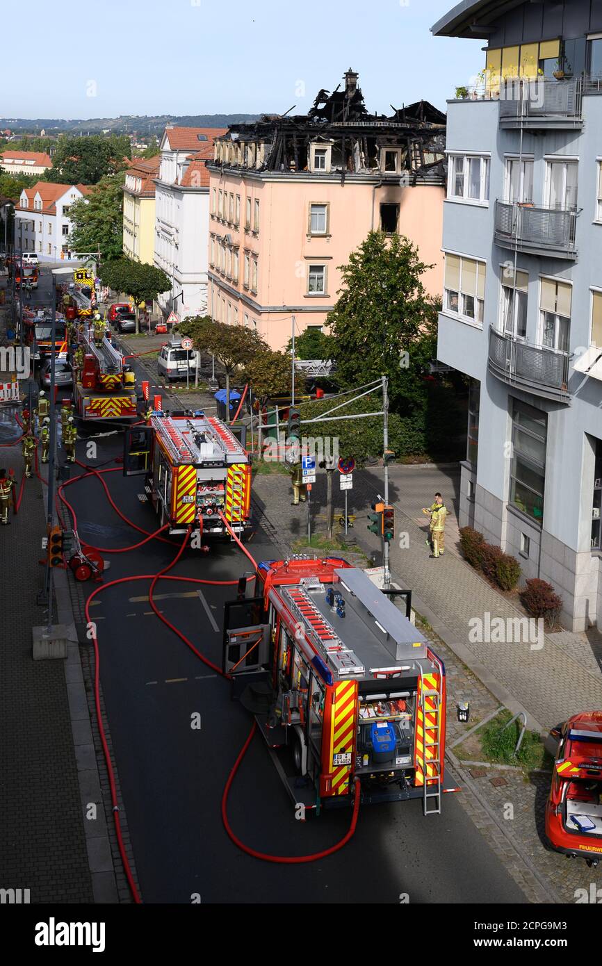 Dresda, Germania. 19 Settembre 2020. I veicoli di emergenza della vigile del fuoco si trovano di fronte a un edificio di appartamenti dopo un incendio. Si dice che il fuoco sia iniziato in un appartamento al secondo piano e poi si è allargato alla capriata del tetto attraverso il controsoffitto. Un uomo saltò fuori dalla finestra della casa il sabato mattina per salvarsi dal fuoco. Gli è stato immediatamente dato cure mediche di emergenza e portato in un ospedale. Non ci sono state altre lesioni. Credit: Sebastian Kahnert/dpa-Zentralbild/dpa/Alamy Live News Foto Stock