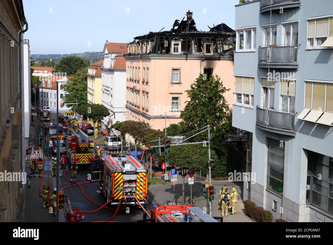 Dresda, Germania. 19 Settembre 2020. I veicoli di emergenza della vigile del fuoco si trovano di fronte a un edificio di appartamenti dopo un incendio. Si dice che il fuoco sia iniziato in un appartamento al secondo piano e poi si è allargato alla capriata del tetto attraverso il controsoffitto. Un uomo saltò fuori dalla finestra della casa il sabato mattina per salvarsi dal fuoco. Gli è stato immediatamente dato cure mediche di emergenza e portato in un ospedale. Non ci sono state altre lesioni. Credit: Sebastian Kahnert/dpa-Zentralbild/dpa/Alamy Live News Foto Stock