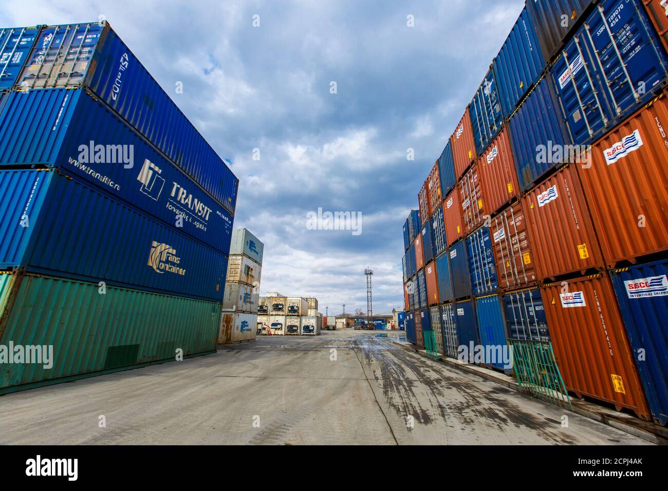 Terminale del contenitore. I contenitori in metallo si trovano in file dritte in un magazzino di stoccaggio aperto Foto Stock