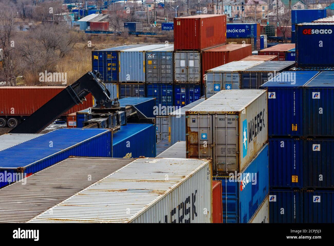 Terminale del contenitore. I contenitori in metallo si trovano in file dritte in un magazzino di stoccaggio aperto Foto Stock