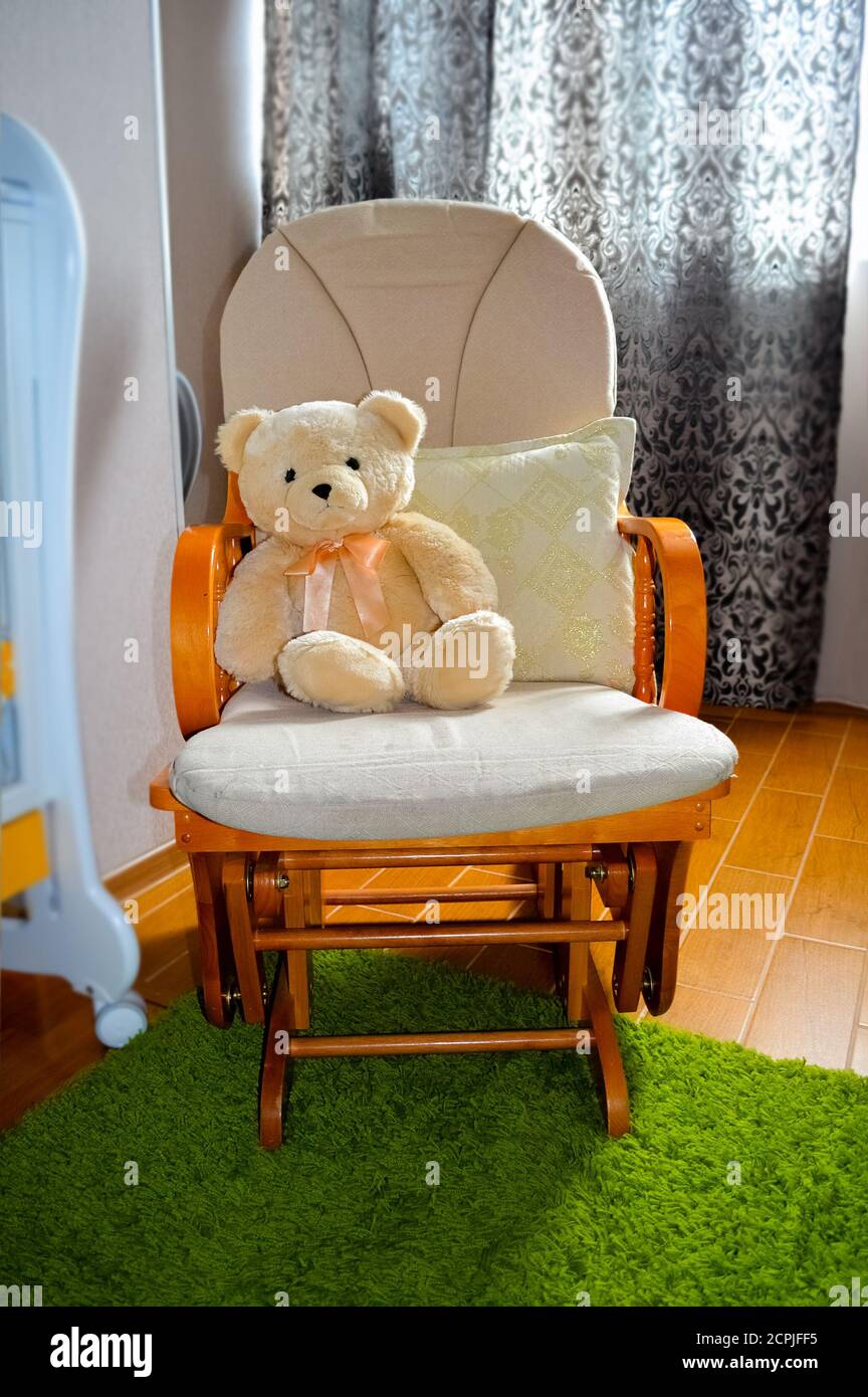 Orsacchiotto in sedia a dondolo all'interno della camera dei bambini Foto Stock