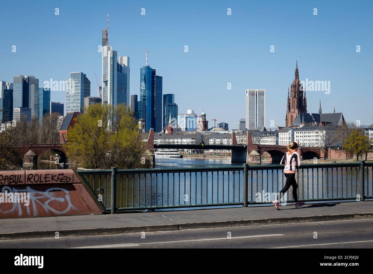 Jogging sulla Mainbrücke di fronte allo skyline del centro di Francoforte con il quartiere finanziario, Francoforte sul meno, Assia, Germania Foto Stock