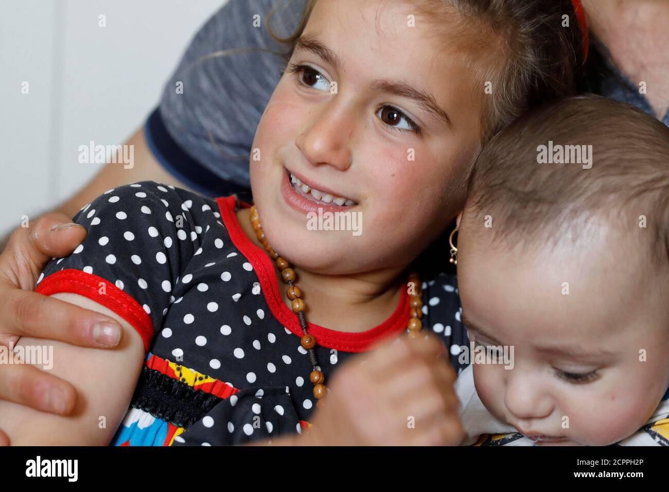 Christina Ezzo Abada irachena, ex ostaggio di militanti dello Stato islamico per tre anni, sorride mentre posa con suo fratello e nipote in una casa ristretta in un campo profughi a Erbil, Iraq, 10 giugno 2017. REUTERS/Erik De Castro Foto Stock