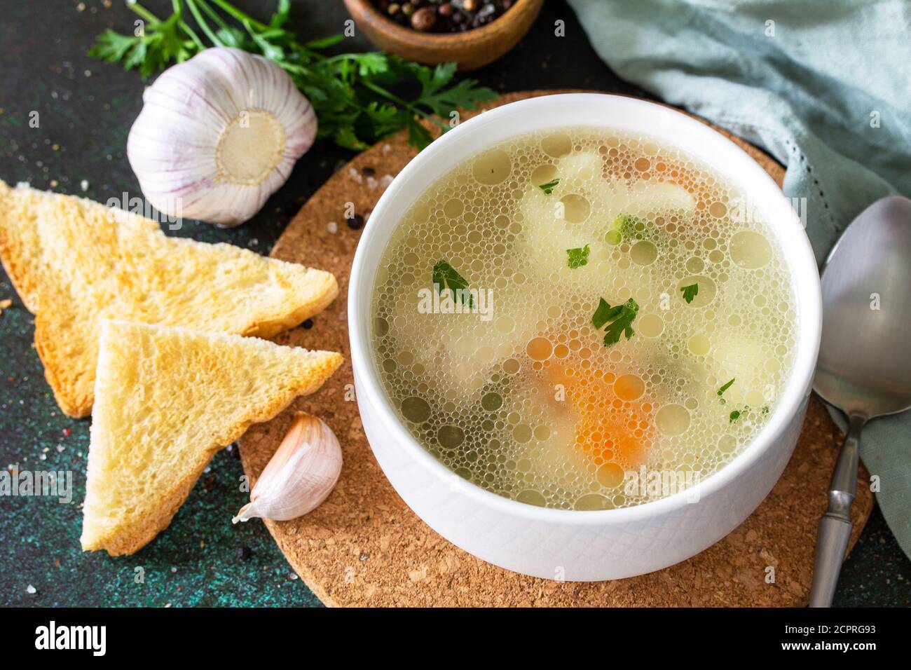 Zuppa di pollo con verdure su un tavolo in pietra scura. Foto Stock